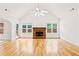 Spacious living room boasts hardwood floors, fireplace, and natural light from multiple windows at 124 Crown Walk, Mcdonough, GA 30253