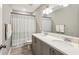 Bathroom featuring double sink vanity with ample counter space, mirror, and shower with decorative curtain at 2624 Chase Rdg, Kennesaw, GA 30144