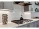 Close up of a modern gas cooktop with subway tile backsplash, and custom cabinets at 2624 Chase Rdg, Kennesaw, GA 30144