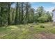 Backyard with lush green grass and mature trees providing ample shade at 2003 Greeson Rd, Dacula, GA 30019