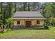 New home under construction with stone and siding, porch and stone chimney surrounded by green grass and trees at 2003 Greeson Rd, Dacula, GA 30019