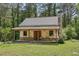 New home under construction with stone and siding, porch and stone chimney surrounded by lush, mature trees at 2003 Greeson Rd, Dacula, GA 30019