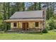 New home under construction with stone and siding, covered porch and stone chimney surrounded by mature trees at 2003 Greeson Rd, Dacula, GA 30019