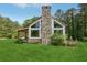 Exterior view featuring a stone chimney, covered porch, and a sprawling green lawn at 2003 Greeson Rd, Dacula, GA 30019