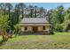 New home under construction with stone and siding, covered porch and stone chimney surrounded by lush, mature trees at 2003 Greeson Rd, Dacula, GA 30019
