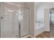 Bright bathroom featuring a glass shower, and a tiled tub with warm colored flooring at 2320 Ivy Birch Ln, Buford, GA 30519