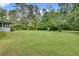 Expansive green backyard featuring lush trees and a view of the home's screened-in sunroom at 2653 Elkhart Sw Cir, Marietta, GA 30064