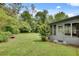Backyard with lush lawn, mature trees, and screened in porch entrance at 2653 Elkhart Sw Cir, Marietta, GA 30064