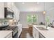 Well-lit kitchen with a gas range, white countertops, and stainless steel sink with dining area nearby at 3219 Blackshear Dr, Marietta, GA 30060