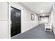 Well-lit hallway with wainscoting, neutral carpet, and white trim leading to the entrance door at 4100 Paces Se Walk # 2304, Atlanta, GA 30339