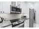 Modern kitchen boasts stainless steel appliances, stylish backsplash, and custom cabinetry at 4100 Paces Se Walk # 2304, Atlanta, GA 30339