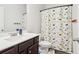 Bathroom featuring single sink vanity, toilet, and dinosaur patterned shower curtain at 66 Cottontail Ln, Loganville, GA 30052