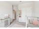 Bedroom featuring a modern crib and gray dresser with white trim at 66 Cottontail Ln, Loganville, GA 30052