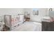 Bright Bedroom with neutral tones and gray crib, large window and a soft, plush rug at 66 Cottontail Ln, Loganville, GA 30052