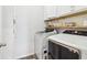 Laundry room with modern washer and dryer, overhead cabinets, and decorative backsplash at 66 Cottontail Ln, Loganville, GA 30052