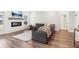 Inviting living room with wood floors, a cozy fireplace, and a large, comfortable leather sectional sofa at 66 Cottontail Ln, Loganville, GA 30052