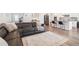 Open concept living room with kitchen and features a gray leather sectional sofa and patterned rug at 66 Cottontail Ln, Loganville, GA 30052