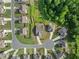 Overhead view of homes in a cul-de-sac with manicured lawns and mature trees, surrounded by lush greenery at 7995 Brewton Creek Dr, Cumming, GA 30028