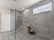 This bathroom features a zero-entry glass shower, tiled wall with a built-in shelf and a concrete bench at 7995 Brewton Creek Dr, Cumming, GA 30028