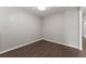 An empty bedroom showcasing modern dark wood floors, crisp white trim, and neutral paint at 7995 Brewton Creek Dr, Cumming, GA 30028