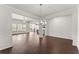 Open-concept dining area featuring wood floors, modern chandelier, and ample space for entertaining at 7995 Brewton Creek Dr, Cumming, GA 30028