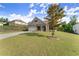 A spacious front yard leads up to this shingle and brick home with an attached garage and beautiful blue skies above at 7995 Brewton Creek Dr, Cumming, GA 30028