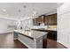 Well-lit kitchen with granite countertops, stainless steel appliances, a center island, and dark wood cabinets at 7995 Brewton Creek Dr, Cumming, GA 30028