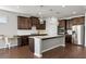 Modern kitchen features dark wood cabinets, stainless steel appliances, granite countertops, and pendant lighting at 7995 Brewton Creek Dr, Cumming, GA 30028