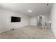 Open living space with neutral carpet, with a mounted flatscreen TV and ample lighting at 7995 Brewton Creek Dr, Cumming, GA 30028