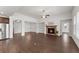Open-concept living room featuring hardwood floors, a stone fireplace, and seamless flow into the kitchen, perfect for modern living at 7995 Brewton Creek Dr, Cumming, GA 30028