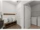 Mudroom with bench, hooks, and storage, next to the laundry room with modern washer and dryer at 7995 Brewton Creek Dr, Cumming, GA 30028