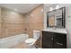 Bathroom featuring shower-tub combo with tile surround and dark vanity at 1131 Mayfield Dr, Decatur, GA 30033