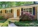 A close-up of the front entrance, highlighting the brick facade, wooden door, and manicured landscaping at 1131 Mayfield Dr, Decatur, GA 30033