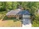 Aerial view of a charming ranch-style home with brick facade, attached garage, and mature trees at 1131 Mayfield Dr, Decatur, GA 30033