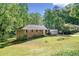 Aerial view of a charming ranch-style home with brick facade, attached garage, and mature trees at 1131 Mayfield Dr, Decatur, GA 30033