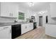 Modern kitchen with white cabinets, sleek appliances, granite countertops, and wood-style flooring at 1131 Mayfield Dr, Decatur, GA 30033