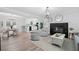 Open concept living room with a fireplace, modern lighting, and views into the kitchen and dining area at 1131 Mayfield Dr, Decatur, GA 30033