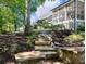 Landscaped backyard with stone steps leading to a serene seating area, perfect for relaxation at 1963 Skybrooke Ln, Hoschton, GA 30548