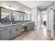Well-lit bathroom with granite countertops, tiled floors, dual sinks, and linen storage showcases a luxurious space at 1963 Skybrooke Ln, Hoschton, GA 30548
