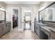 An elegant bathroom features double vanities, granite countertops, and a view into a spacious walk-in closet at 1963 Skybrooke Ln, Hoschton, GA 30548