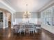 Formal dining room featuring a large window, wainscoting, and an elegant chandelier at 1963 Skybrooke Ln, Hoschton, GA 30548