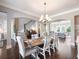 Open-concept dining room showcasing hardwood floors, large chandelier, and natural light at 1963 Skybrooke Ln, Hoschton, GA 30548