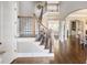 Grand foyer with hardwood floors, staircase with iron spindles, and views into adjacent living spaces at 1963 Skybrooke Ln, Hoschton, GA 30548