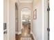 Hallway with arched doorway leads to an open kitchen with stainless steel appliances and an island with stone accents at 1963 Skybrooke Ln, Hoschton, GA 30548