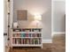 Hallway featuring a stylish console table with bookshelves, complemented by hardwood flooring and neutral wall colors at 1963 Skybrooke Ln, Hoschton, GA 30548