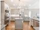 Bright kitchen features stainless steel appliances, grey cabinets, granite countertops, and a kitchen island at 1963 Skybrooke Ln, Hoschton, GA 30548