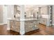 Kitchen island with stone accents, granite countertops, sink, stainless steel appliances, and hardwood floors at 1963 Skybrooke Ln, Hoschton, GA 30548
