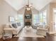Cozy living room with a stone fireplace, cathedral ceiling, hardwood floors, and bright windows at 1963 Skybrooke Ln, Hoschton, GA 30548