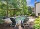 Inviting backyard pool with a waterfall feature, surrounded by lush greenery and lounge seating at 1963 Skybrooke Ln, Hoschton, GA 30548