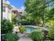 Lush backyard featuring a pristine pool, lounge chairs and umbrella for relaxing and enjoying at 1963 Skybrooke Ln, Hoschton, GA 30548